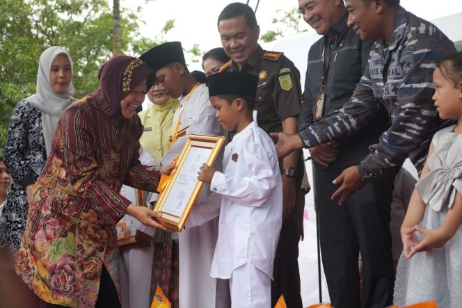 
					Menteri Sosial RI Tri Rismaharini saat melakukan penyerahan secara simbolis Akte Kelahiran dan Kartu Identitas Anak (KIA), (Sumber foto : Kemensos)