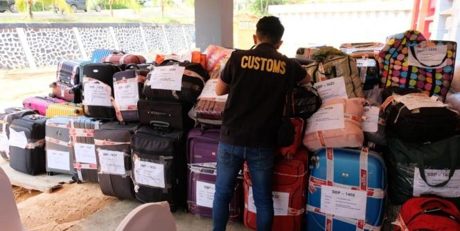 
					Petugas Bea Cukai Batam memeriksa dan menata tumpukan pakaian bekas ilegal hasil penindakan di sejumlah pelabuhan dan bandara selama 2025. Barang bukti ini ditampilkan dalam Konferensi Pers, Selasa (9/12). 