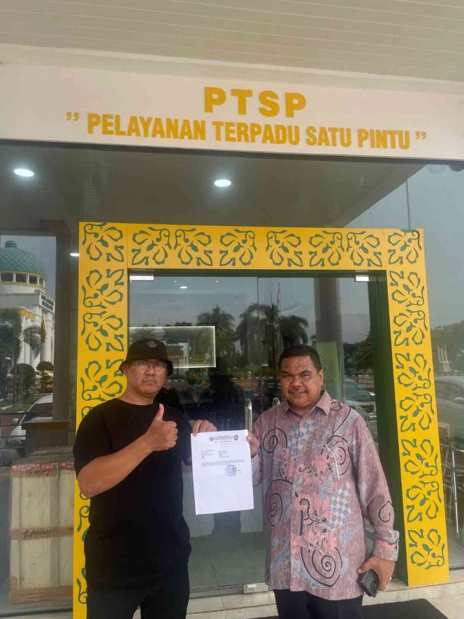 
					Ketua GAMNR Kota Tanjungpinang, Said Ahmad Syukri (kiri), didampingi Humas GAMNR, Riswandi (kanan), menunjukkan surat laporan usai diserahkan di Pelayanan Terpadu Satu Pintu (PTSP) Kejaksaan Tinggi Kepulauan Riau, Senin (25/5/2026). Laporan tersebut terkait pengadaan pakaian dinas di BKAD Provinsi Kepulauan Riau.