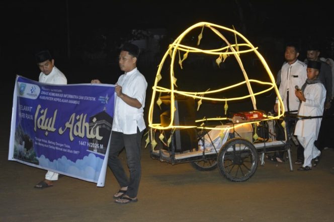 
					Pegawai Diskominfotik Kabupaten Kepulauan Anambas membawa spanduk dan miniatur lampu hias saat mengikuti Pawai Takbir Idul Adha 1447 H di Anambas, Selasa (26/5/2026) malam.
