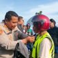 Kapolres Kepulauan Anambas AKBP Gogot Suharjono memasangkan helm kepada salah seorang pengendara saat kegiatan pembagian 50 helm gratis di Astaka Masjid Agung Baitul Ma'mur, Tarempa, Kamis (25/6/2026).