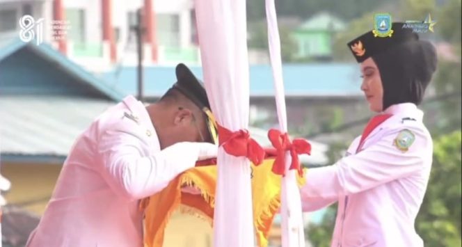 
					Bupati Kepulauan Anambas Aneng mencium Bendera Merah Putih sebelum prosesi pengibaran pada Upacara HUT ke-81 Kemerdekaan RI di Lapangan Sulaiman Abdullah, Tarempa, Senin (17/8/2026). Momen tersebut menjadi simbol penghormatan dan kecintaan terhadap Tanah Air.